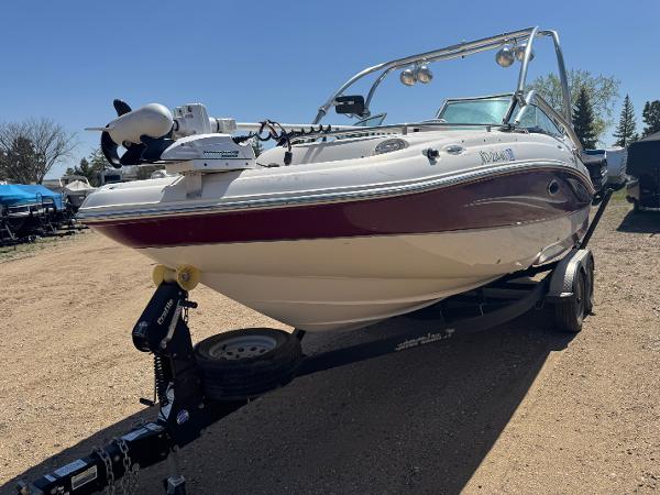 Hurricane SunDeck 2400 I/O 2008 Hurricane SunDeck 2400 I/O boat on trailer, parked outdoors.