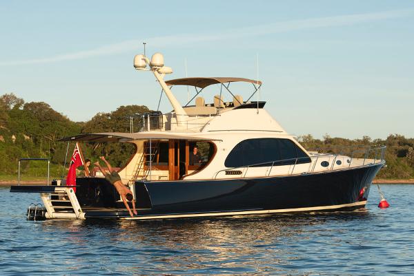 Palm Beach Motor Yachts PB65 2026 Palm Beach Motor Yachts PB65 on serene water with people enjoying the deck.