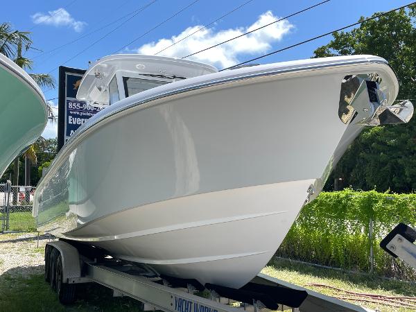 Everglades 315 Center Console 2025 Everglades 315 Center Console boat on trailer, sunny day, lush greenery background.