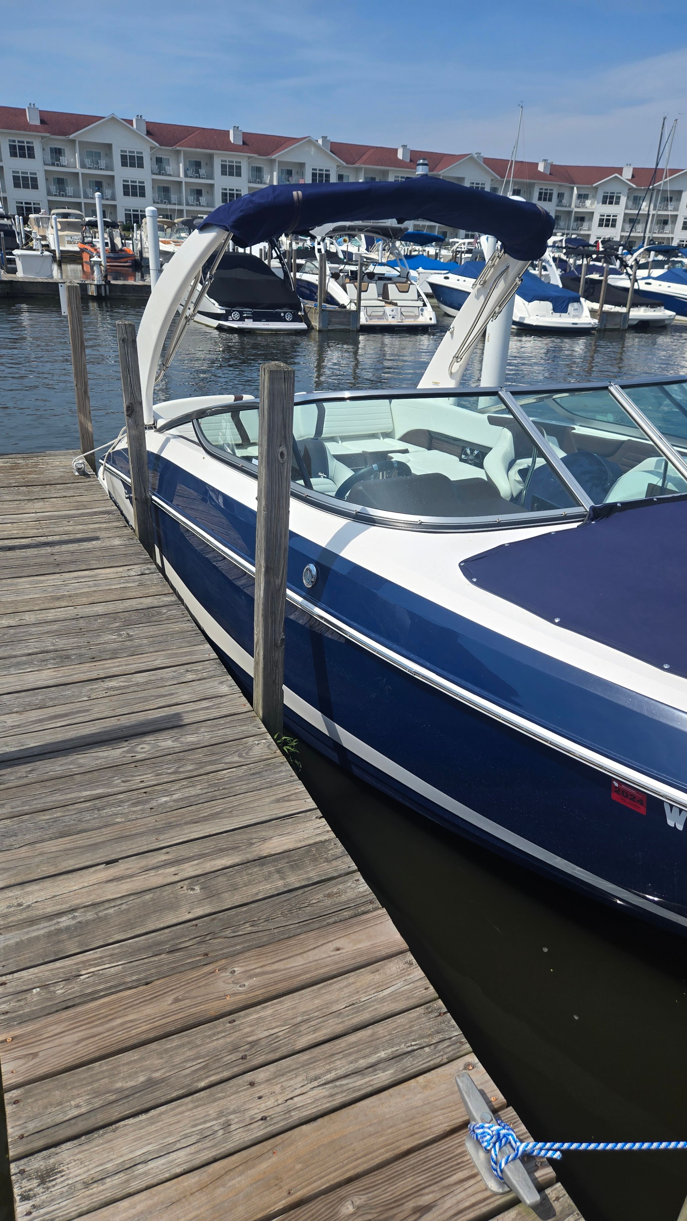 Regal 2500 Bowrider 2017 Regal 2500 Bowrider docked at marina, blue and white design, sunny day.