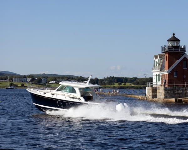 Back Cove 34O 2026 Back Cove 34O boat cruising near a lighthouse on a sunny day.