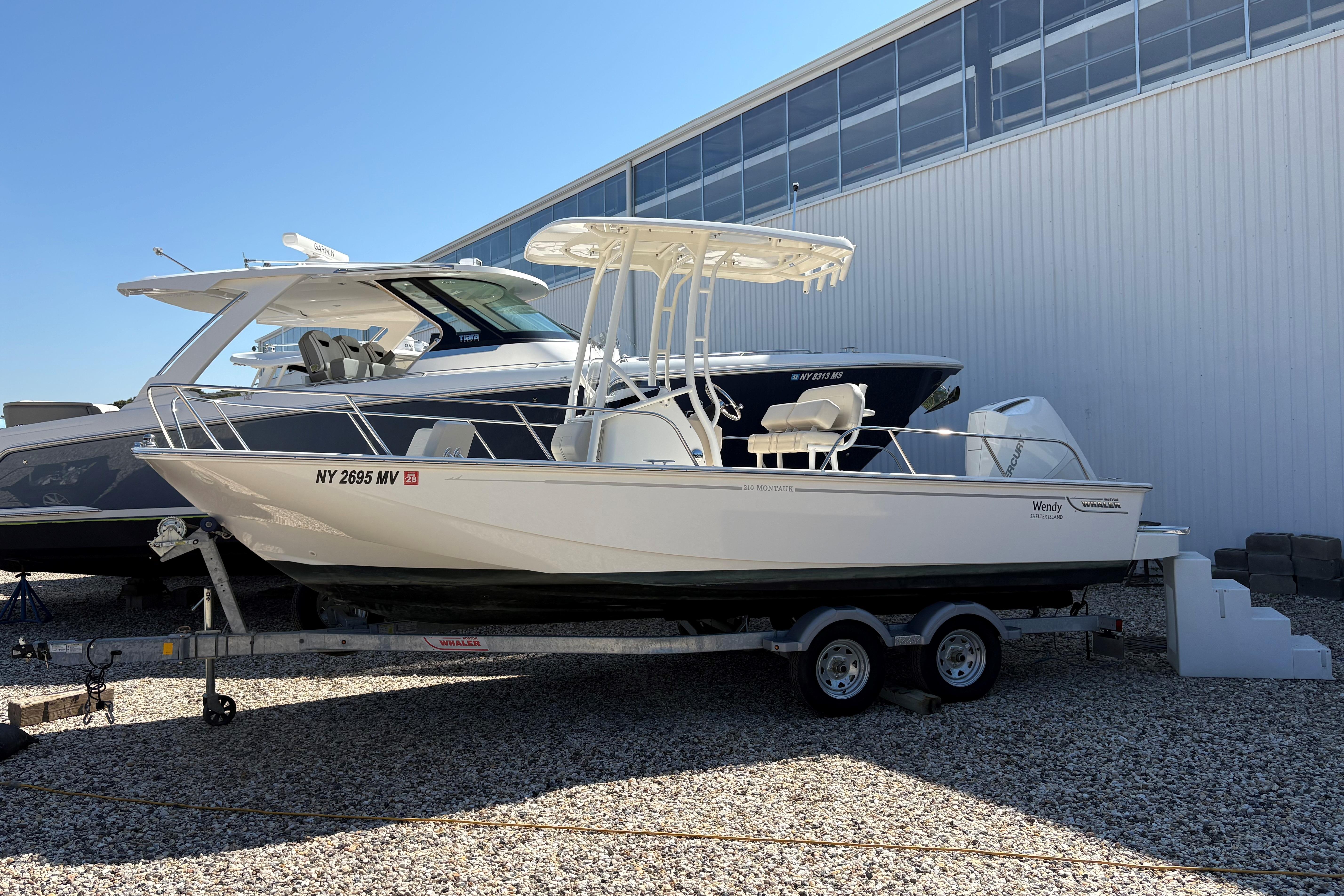 Boston Whaler 210 Montauk 2024 Boston Whaler 210 Montauk boat on trailer, parked outdoors.
