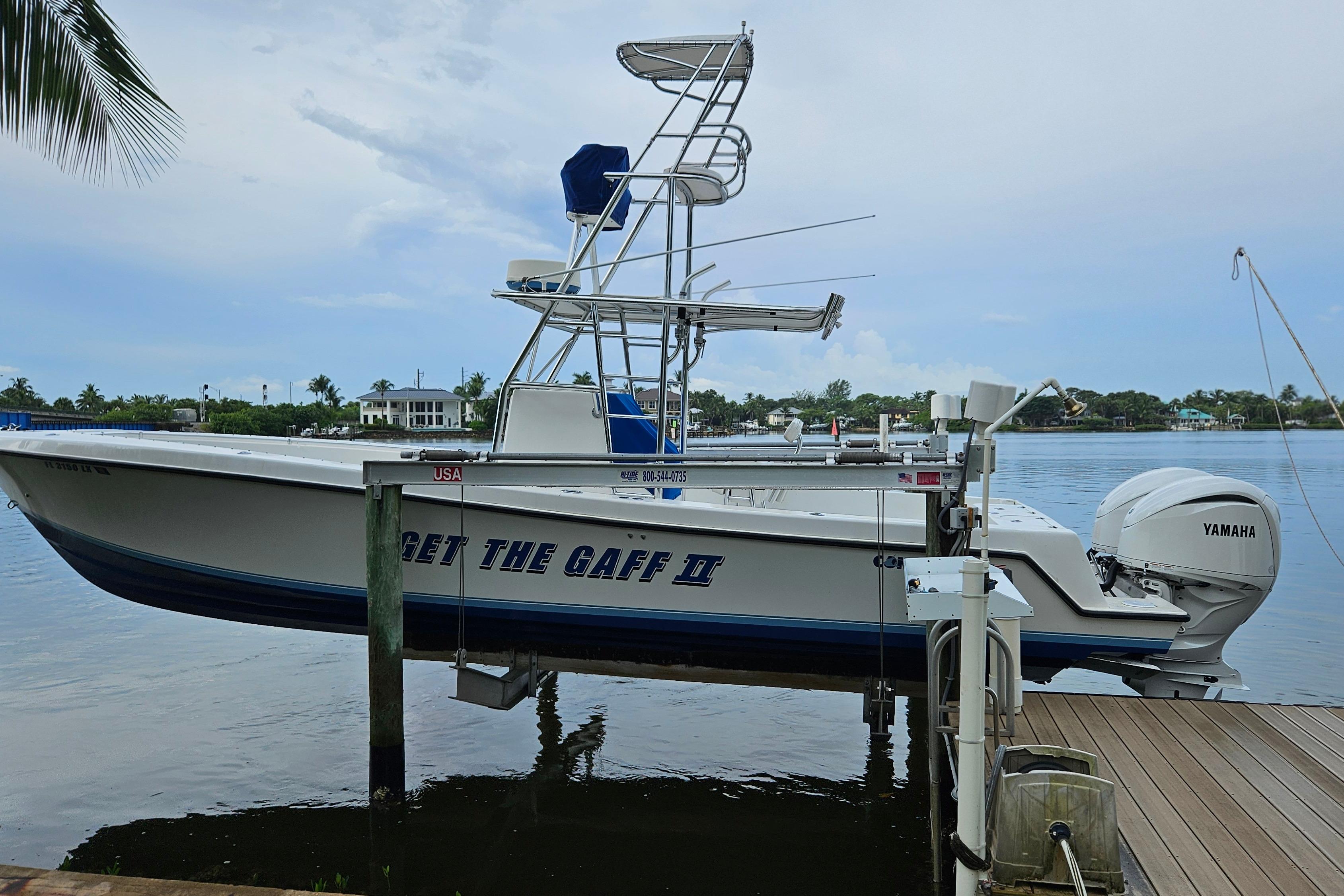 Contender 31 Open 2002 Contender 31 Open boat with Yamaha engine, docked by a serene waterfront.