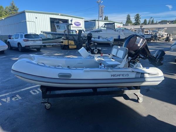 Highfield CL340 FCT 2024 Highfield CL340 FCT inflatable boat on a trailer in a marina parking lot.