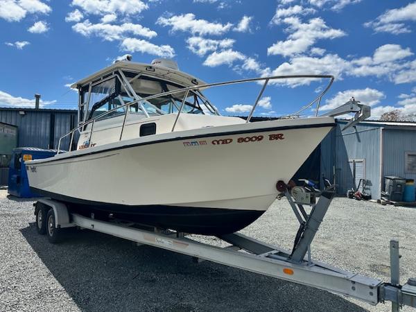 Parker 2510DVWA 2001 Parker 2510DVWA boat on trailer, parked outdoors under a blue sky.
