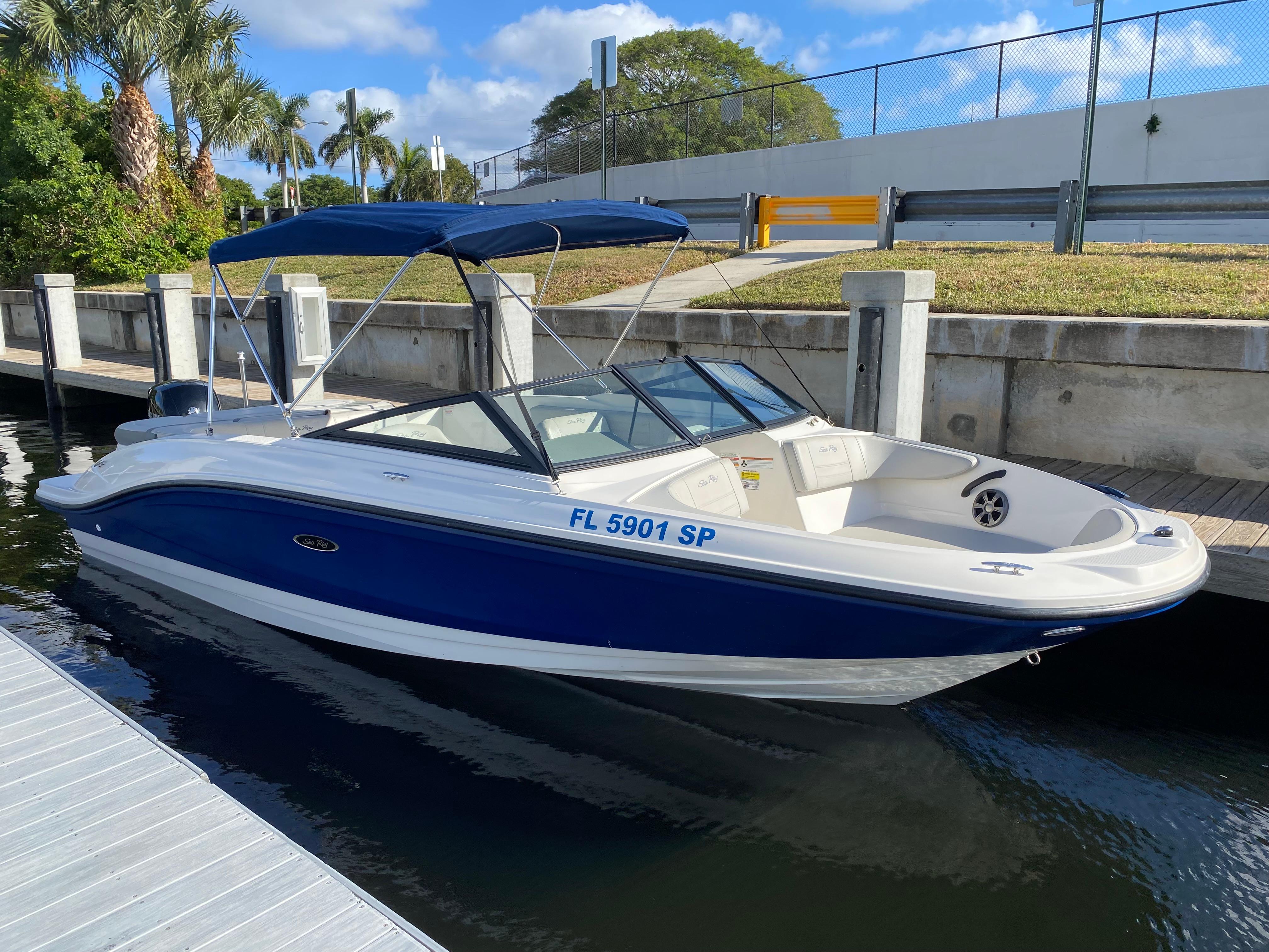 Sea Ray SPX 210 Outboard 2020 Sea Ray SPX 210 Outboard boat docked by a canal under a blue sky.