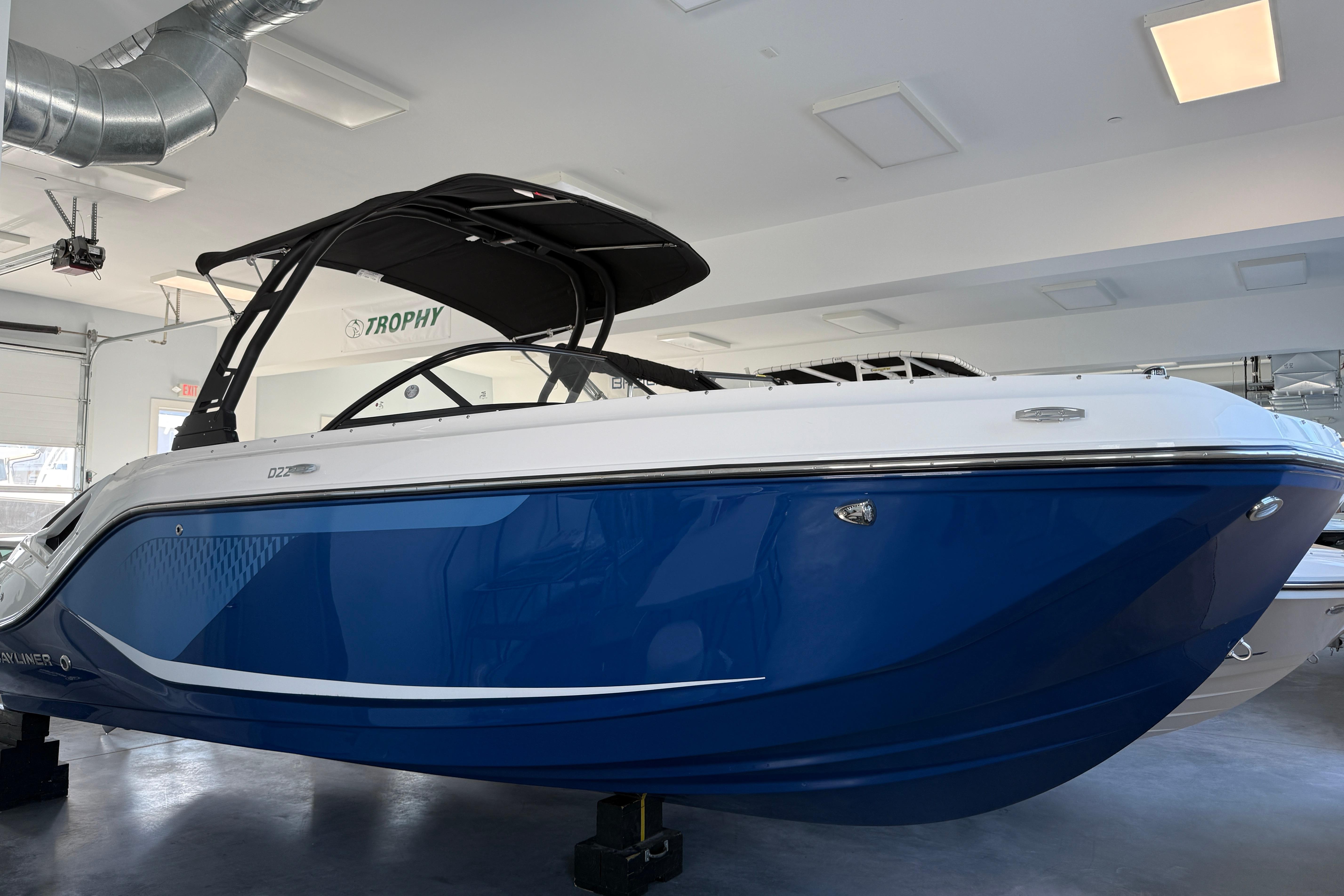 Bayliner D22 2026 Bayliner D22 boat with sleek blue and white design in showroom.