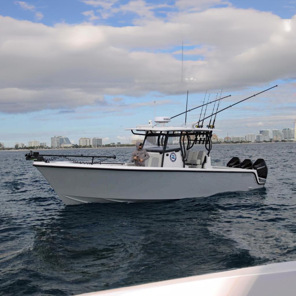 Reef Runner 340 2026 Reef Runner 340 boat on water, equipped with fishing rods and outboard motors.
