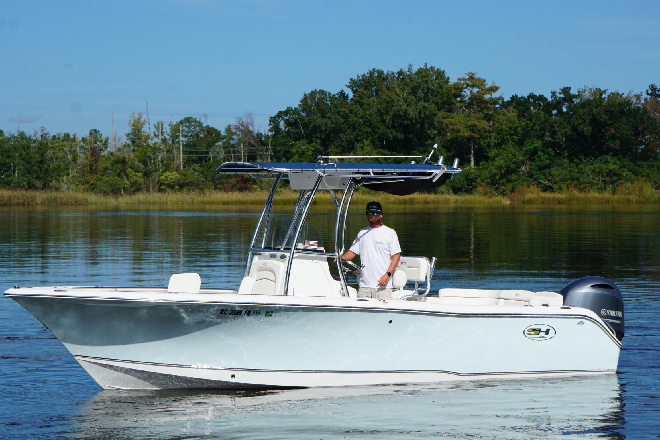 Sea Hunt Ultra 234 2020 Seahunt 234 Ultra boat on calm water with a person at the helm.