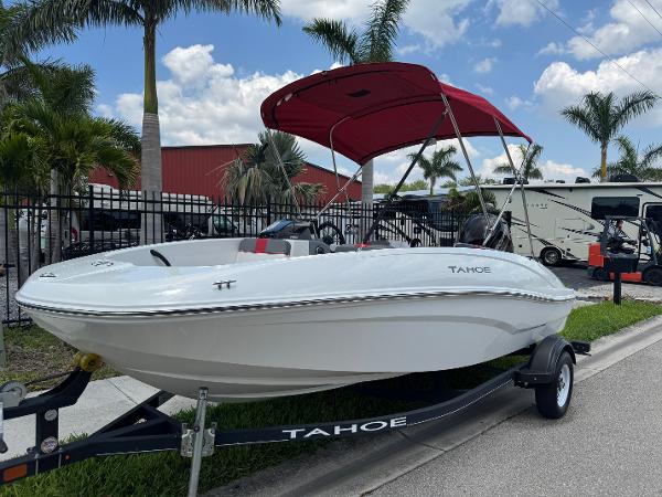 Tahoe T16 2020 Tahoe T16 boat with red canopy on trailer, parked near palm trees.