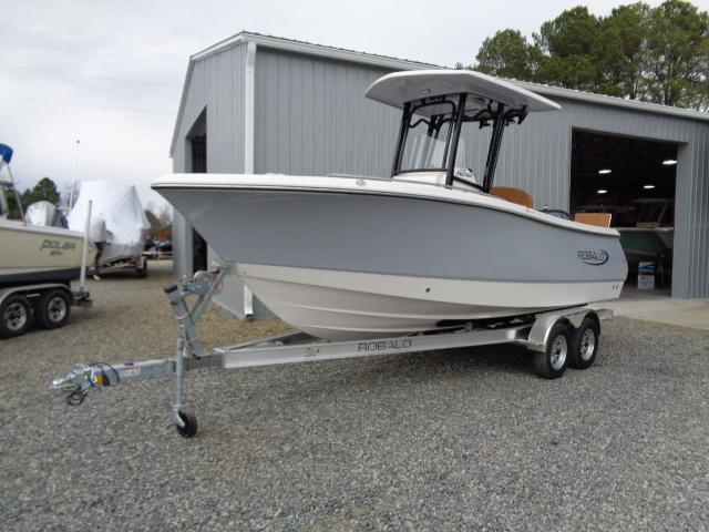 Robalo R230 Center Console 2025 Robalo R230 Center Console boat on trailer, parked outside a metal building.