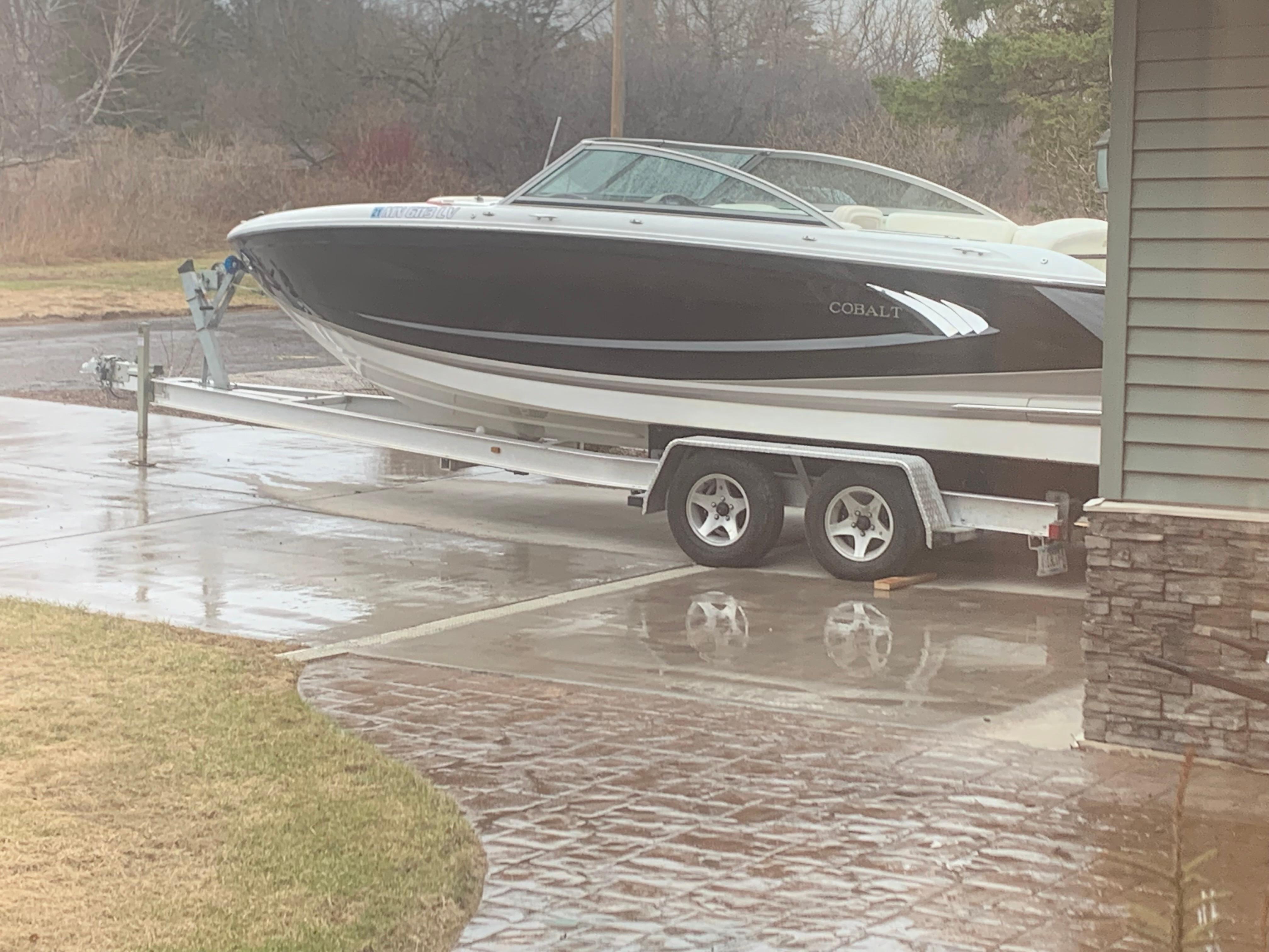 Cobalt A25 2011 Cobalt A25 boat on trailer in driveway, overcast day.