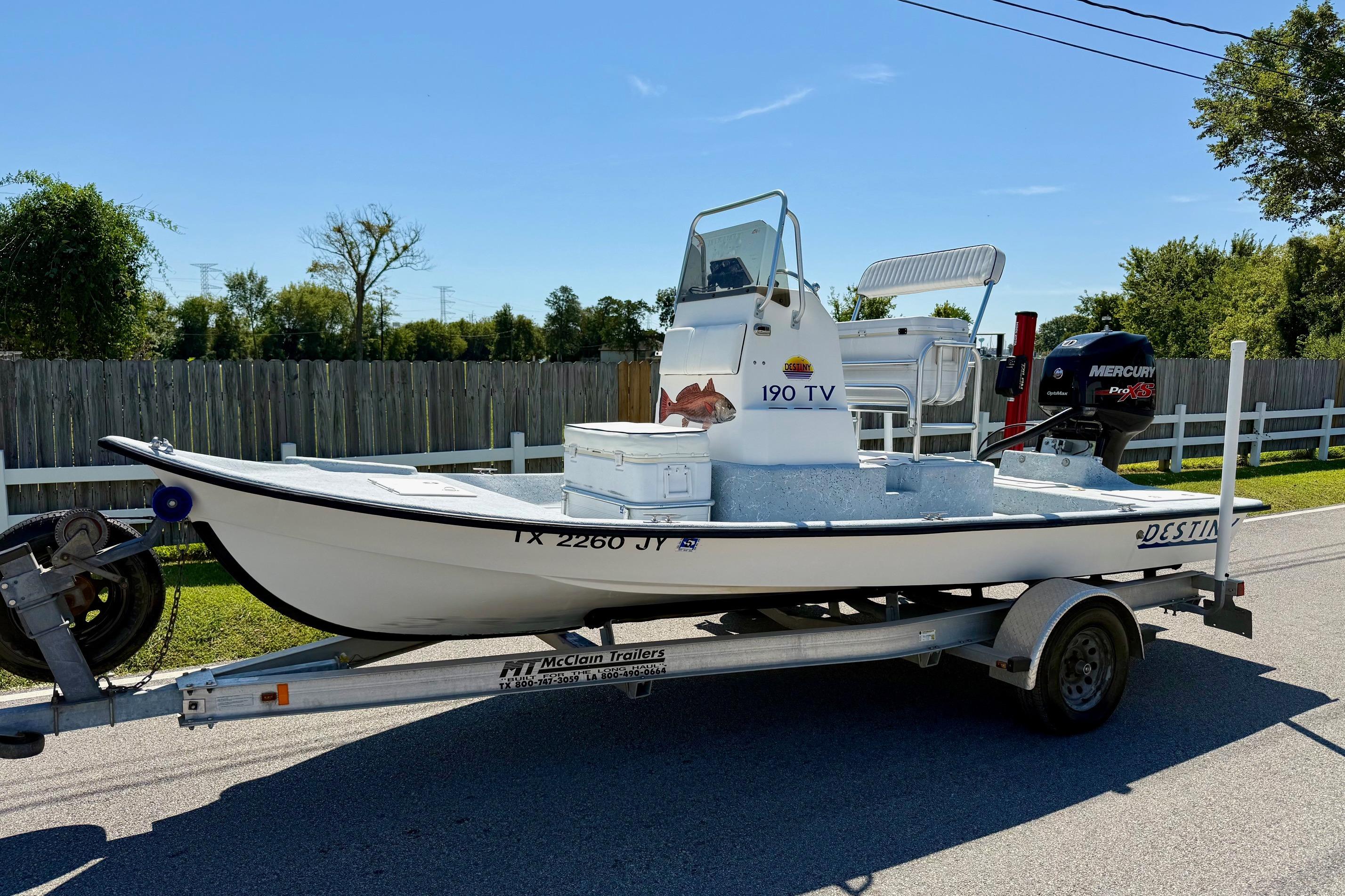 Destiny 190 Tv 2004 Destiny 190 TV boat on trailer with Mercury Pro XS engine, parked on street.