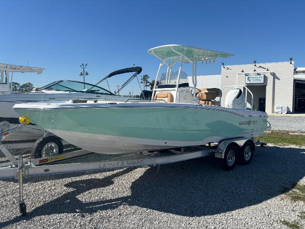 NauticStar 231 Hybrid 2025 NauticStar 231 Hybrid boat on trailer, displayed outdoors under clear blue sky.