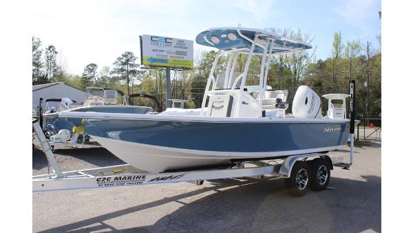 Sea Pro 210 2025 Sea Pro 210 boat on trailer, blue hull, parked outdoors.