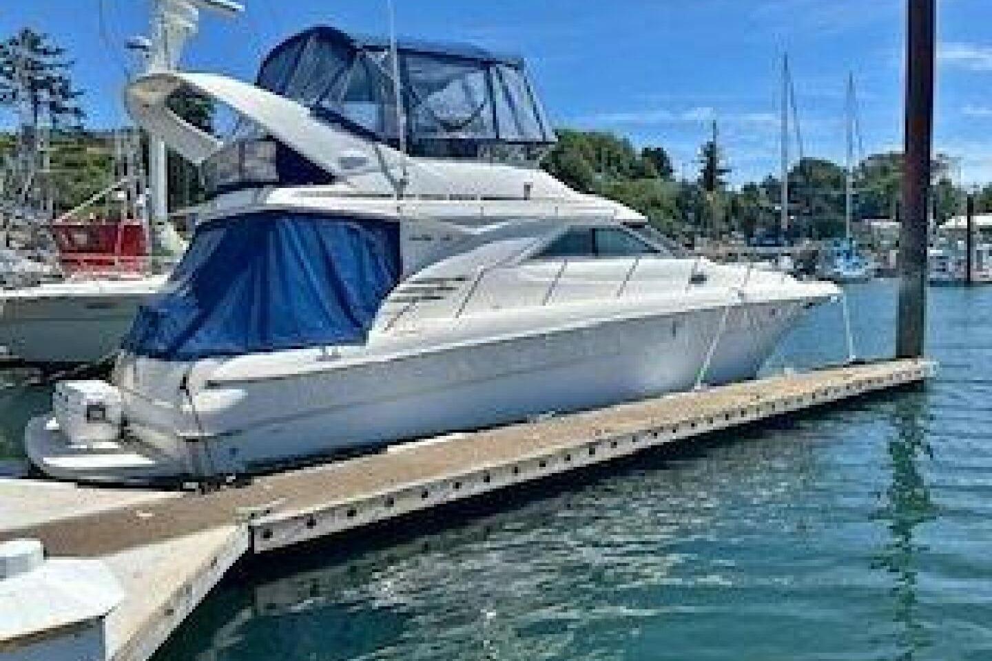 Sea Ray 400 Sedan Bridge 2000 Sea Ray 400 Sedan Bridge yacht docked at marina, featuring blue canopy.