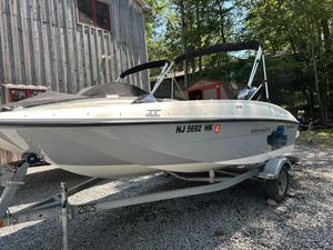 Bayliner Element E16 2019 Bayliner Element E16 boat on trailer, parked near rustic building.