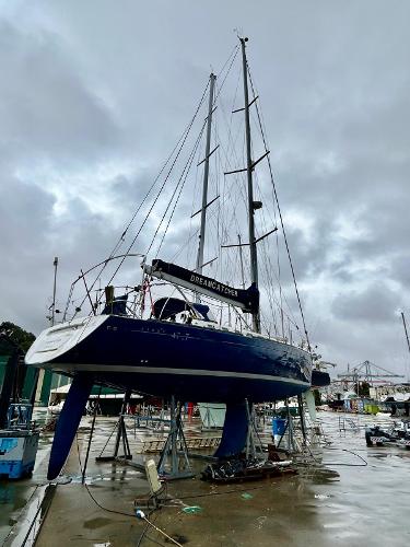Beneteau First 47.7 Beneteau First 47.7 sailboat from 2001 on stands in a marina under cloudy skies.