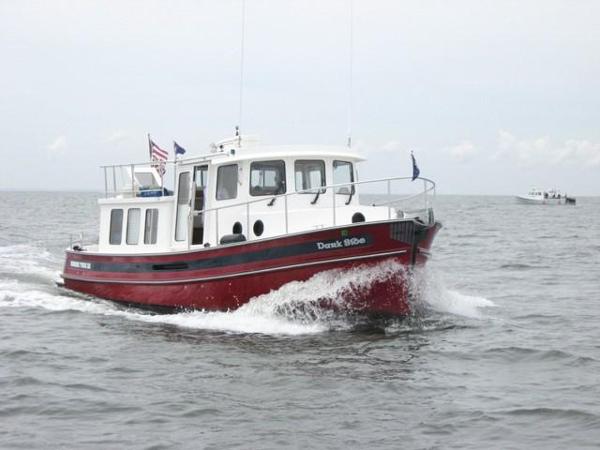 Nordic Tug 32 2005 Nordic Tug 32 cruising on open water, red hull, white cabin.