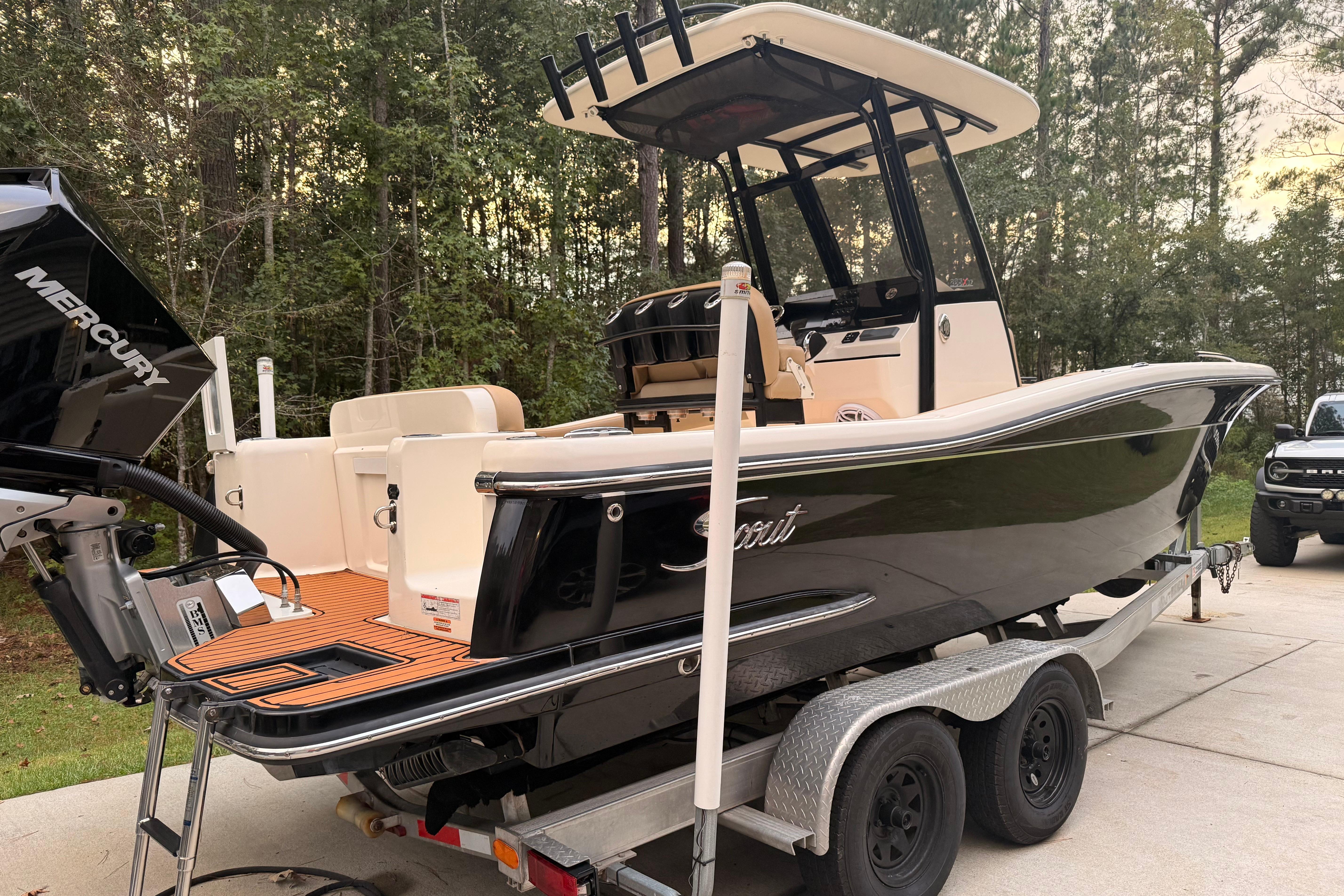 Scout 235 XSF 2021 Scout 235 XSF boat on trailer with Mercury engine, parked outdoors.