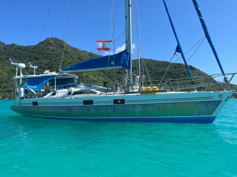 Alubat OVNI 43 Sailing yacht Alubat OVNI 43, 1993, anchored in turquoise waters with lush hills in background.