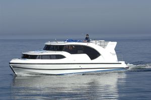 Custom Houseboat Minuetto Custom Houseboat Minuetto 2009 cruising on calm waters under clear skies.