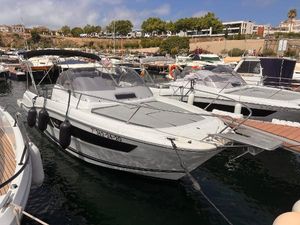 Jeanneau Cap Camarat 9.0 WA 2020 Jeanneau Cap Camarat 9.0WA boat docked in a marina, surrounded by other vessels.
