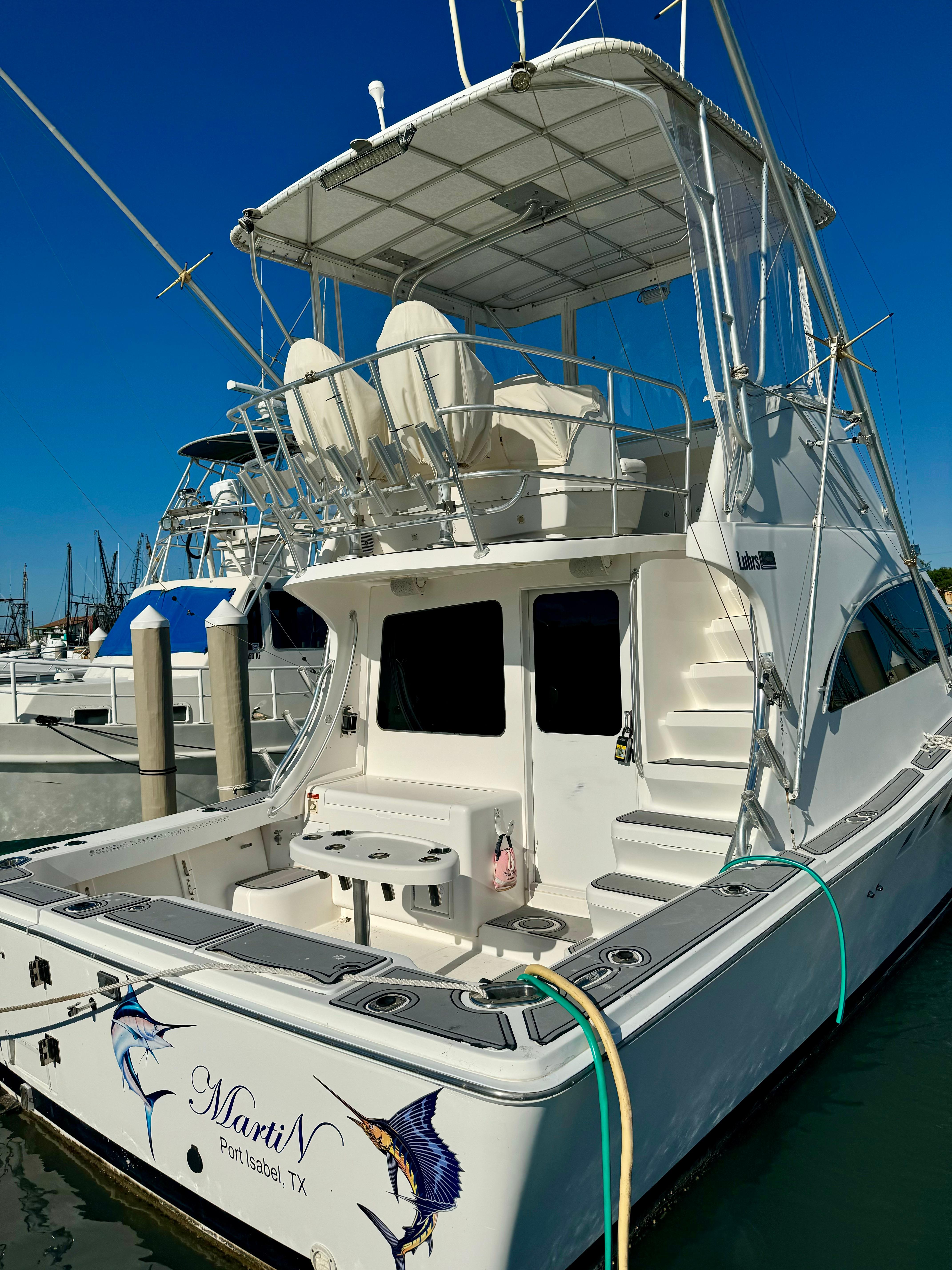 Luhrs 36 Convertible 2002 Luhrs 36 Convertible yacht docked, featuring spacious deck and fishing equipment.