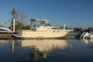 Wellcraft 3300 Coastal 1997 Wellcraft 3300 Coastal boat docked on calm water under clear blue sky.