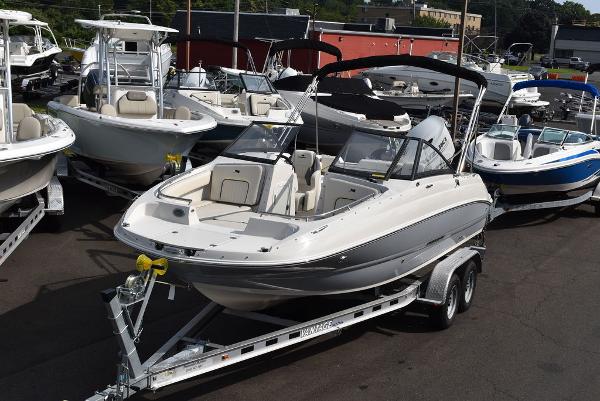 Stingray 201DC 2024 Stingray 201DC boat on trailer, surrounded by other boats in a dealership lot.
