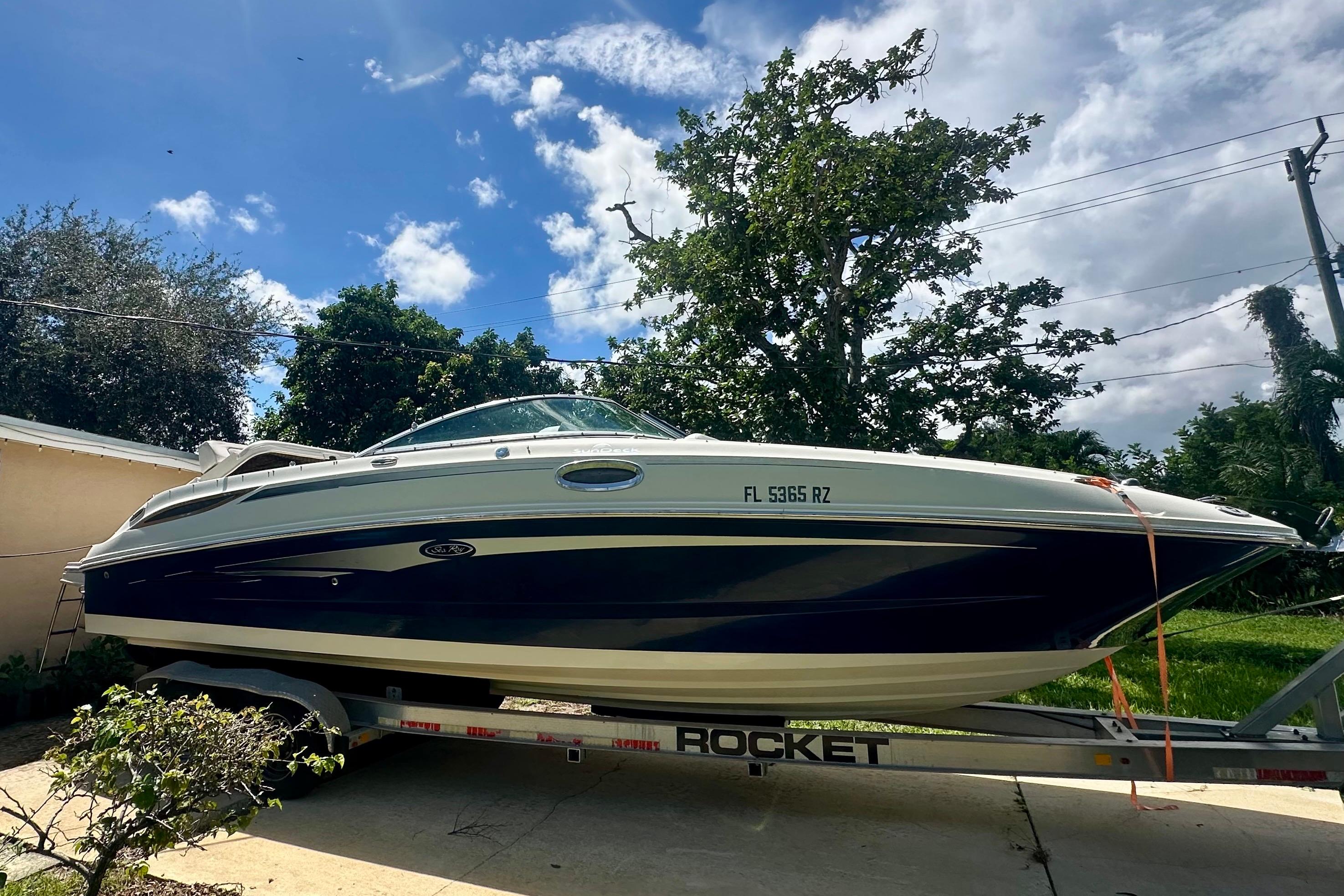 Sea Ray 280 Sundeck 2010 Sea Ray 280 Sundeck boat on trailer, parked outdoors under a blue sky.