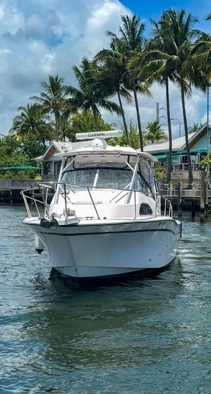 Grady-White Marlin 300 2003 Grady-White Marlin 300 boat on water, surrounded by palm trees and clear skies.