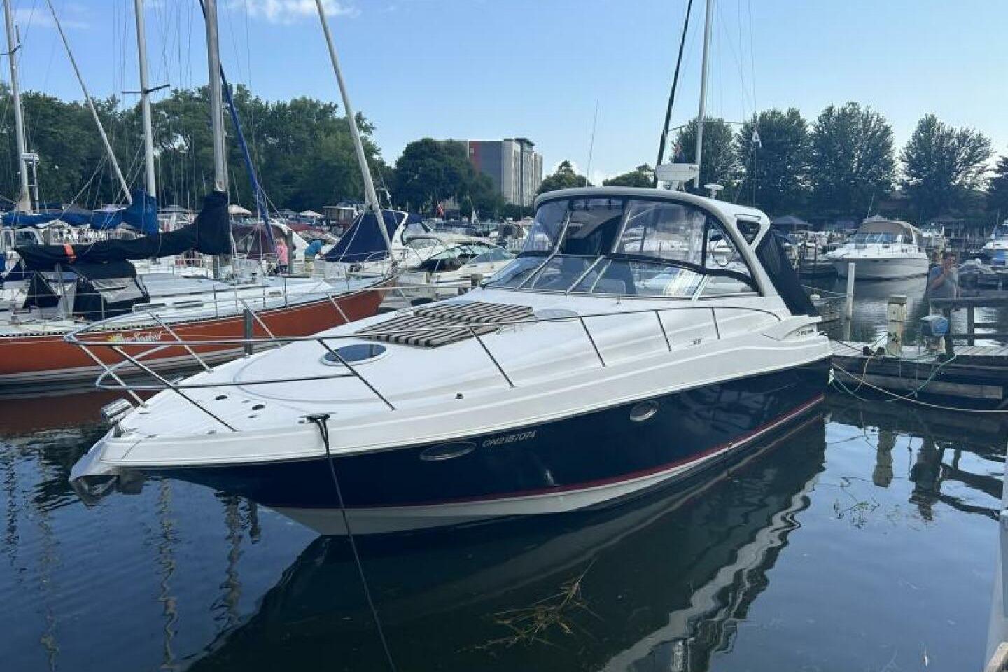 Regal 3760 Commodore 2007 Regal 3760 Commodore yacht docked in a marina, surrounded by sailboats.