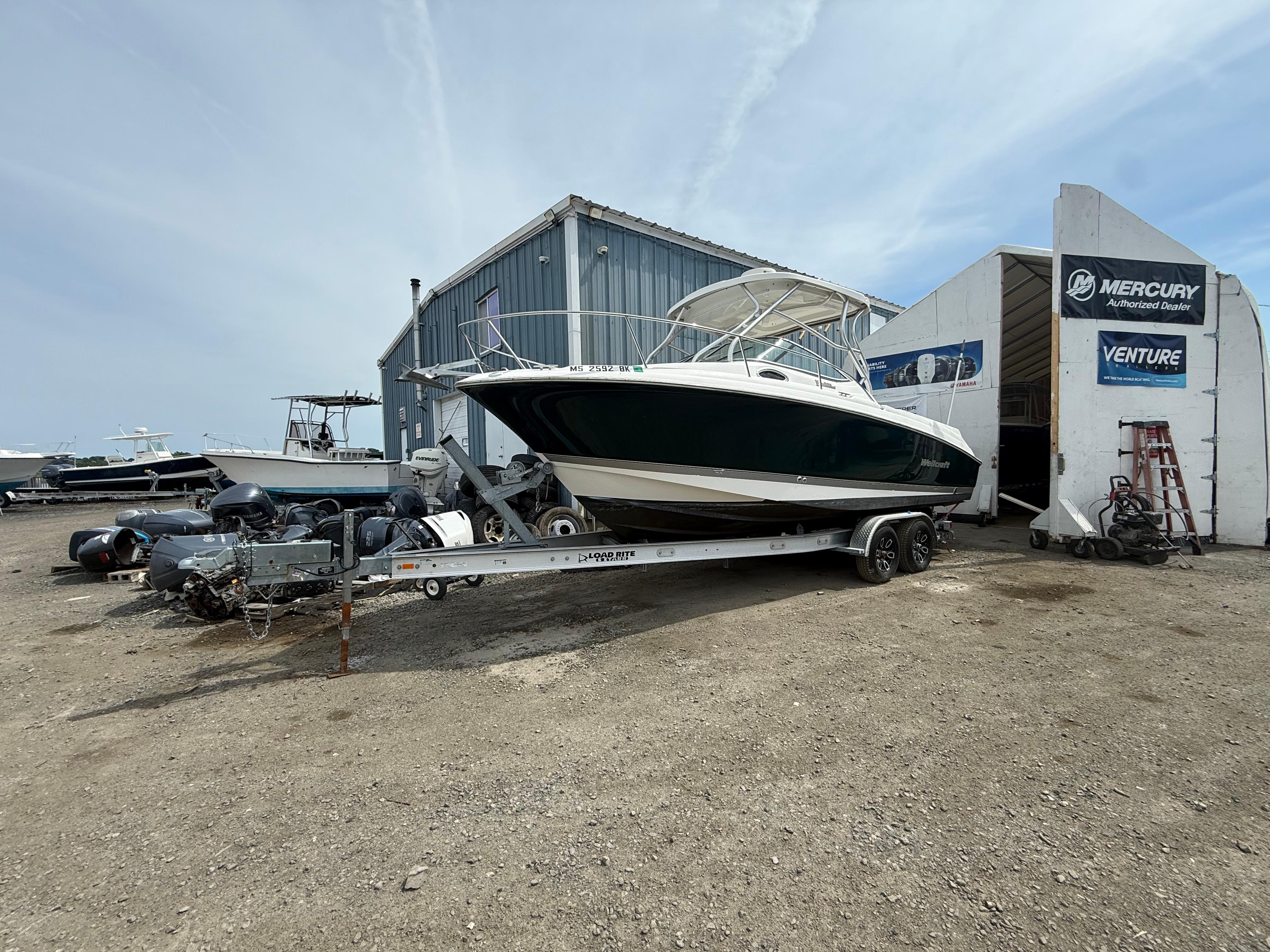 Wellcraft 252 Coastal 2005 Wellcraft 252 Coastal boat on trailer outside Mercury dealer building.