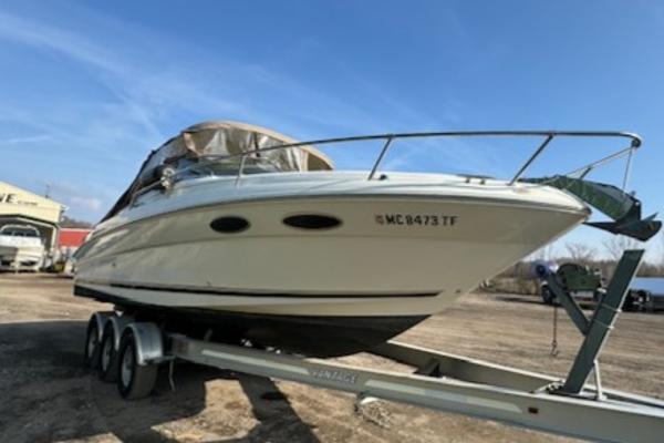 Sea Ray 280 1997 Sea Ray 280 boat on a trailer under a clear blue sky.