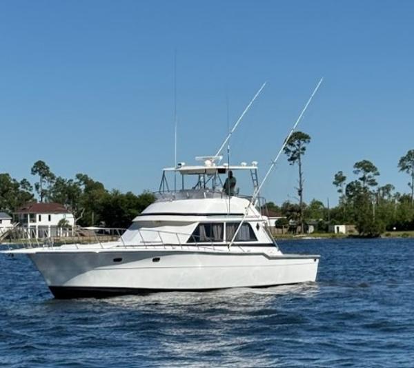 Ricker 48 Convertible 1989 Ricker 48 Convertible yacht cruising on a sunny day near the shoreline.