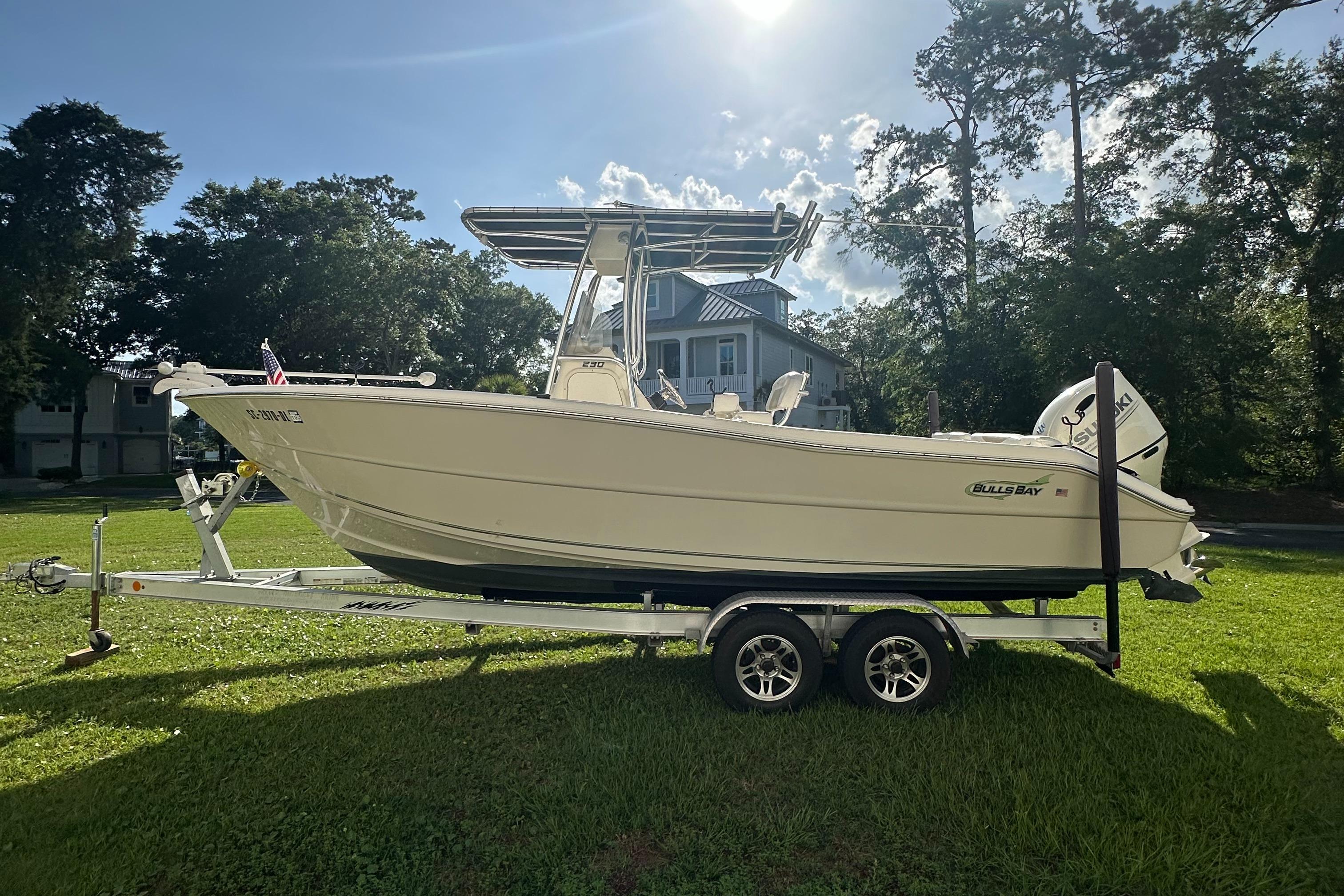 Bulls Bay 230 Center Console 2019 Bulls Bay 230 Center Console boat on trailer, parked on grass with trees in background.
