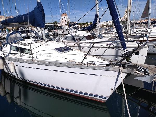 Jeanneau Sun Light 30 1987 Jeanneau Sun Light 30 sailboat docked in a marina, featuring sleek design and blue sails.