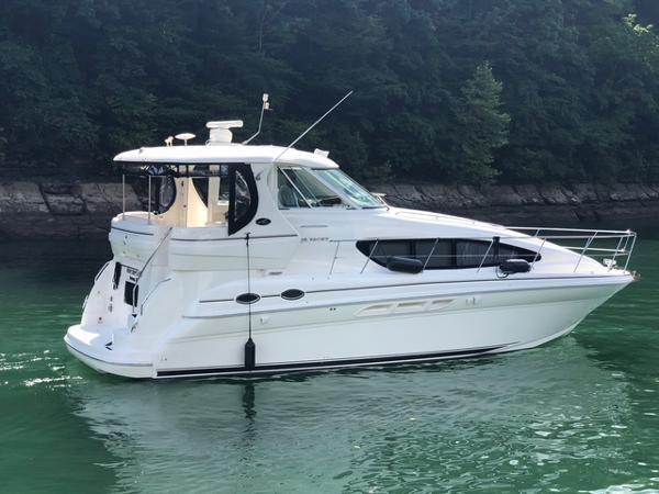 Sea Ray 390 Motor Yacht 2004 Sea Ray 390 Motor Yacht on calm water, surrounded by lush greenery.