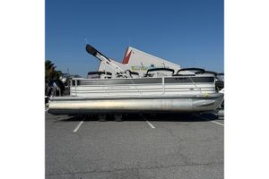 Berkshire 24CL 2.75 LE 2025 Berkshire 24CL 2.75 LE pontoon boat parked outdoors under clear blue sky.