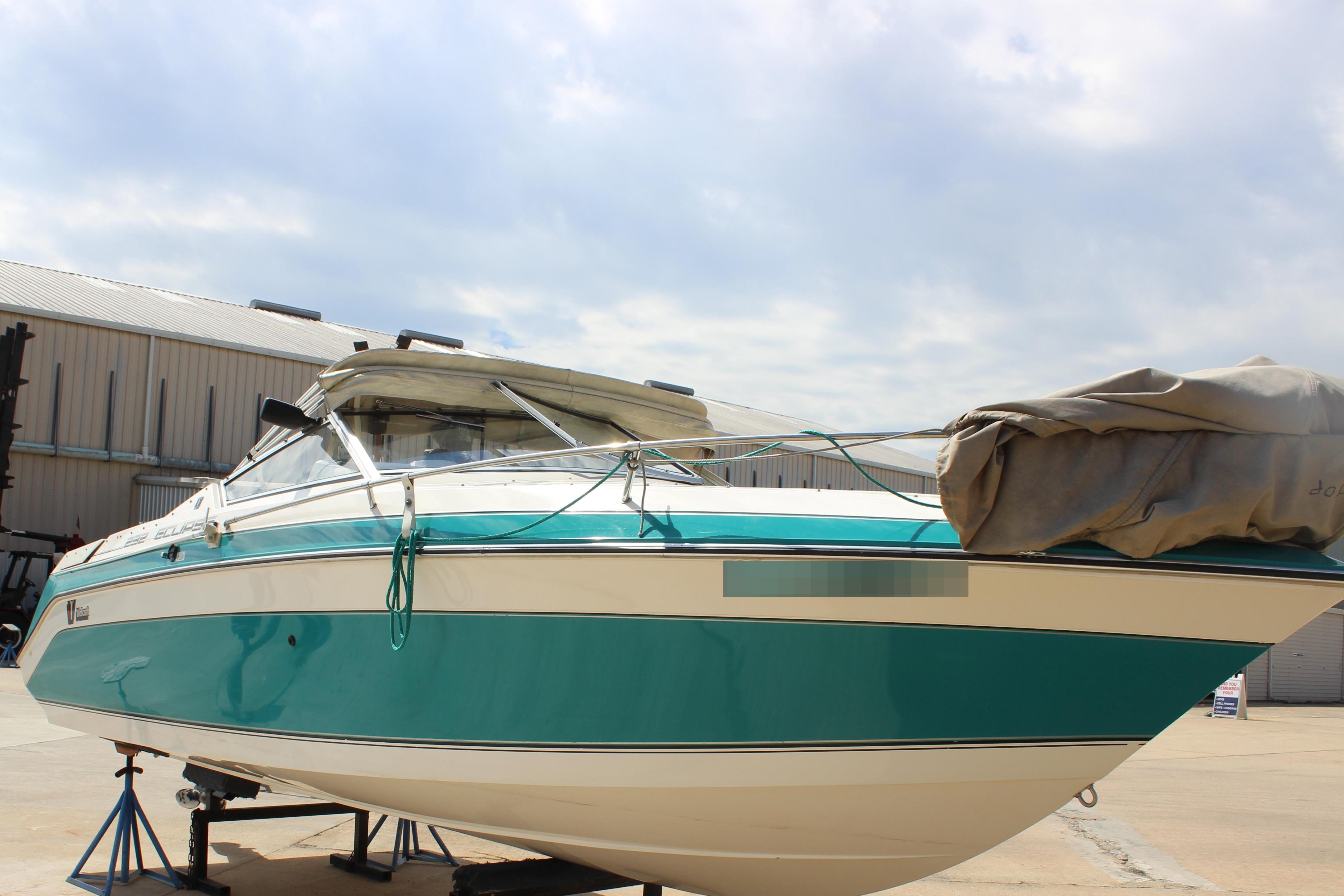 Wellcraft Eclipse 232 1991 Wellcraft Eclipse 232 boat on stands, teal and white design, outdoor setting.