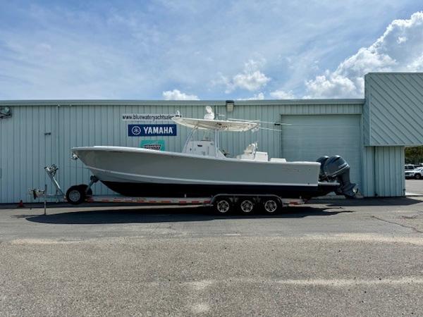 Regulator 31 2017 Regulator 31 boat on trailer outside Yamaha dealership under blue sky.