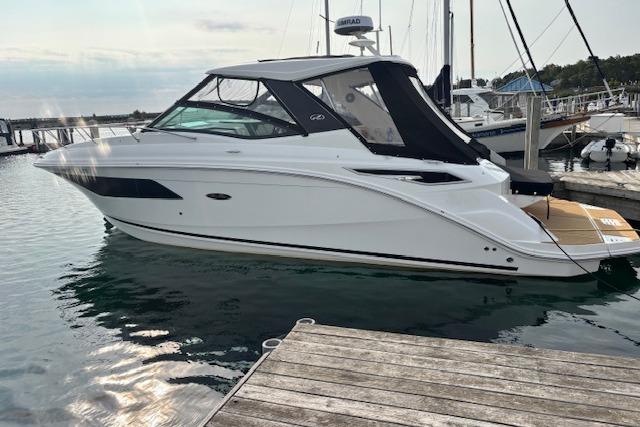 Sea Ray Sundancer 320 2024 Sea Ray Sundancer 320 yacht docked at marina, sleek design, white hull, black canopy.
