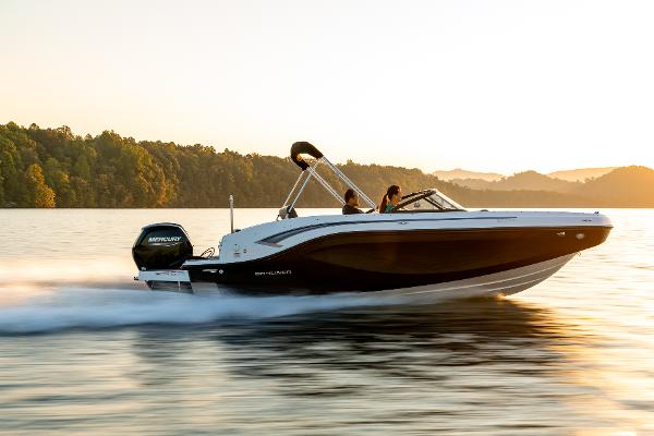 Bayliner DX2000 2023 Bayliner DX2000 boat cruising on a serene lake at sunset.