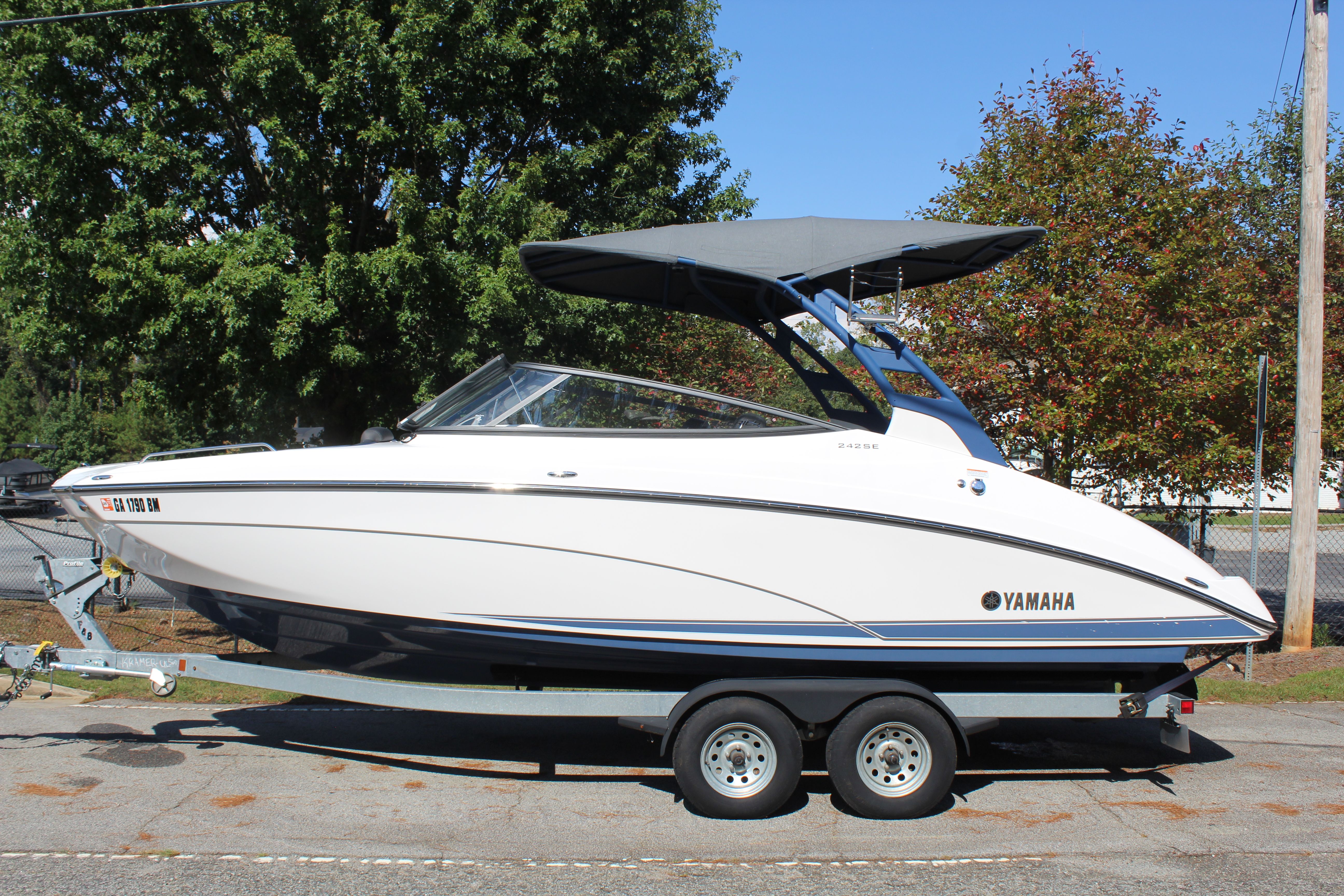 Yamaha Boats 242 SE 2020 Yamaha Boats 242 SE on trailer, parked outdoors with trees in background.