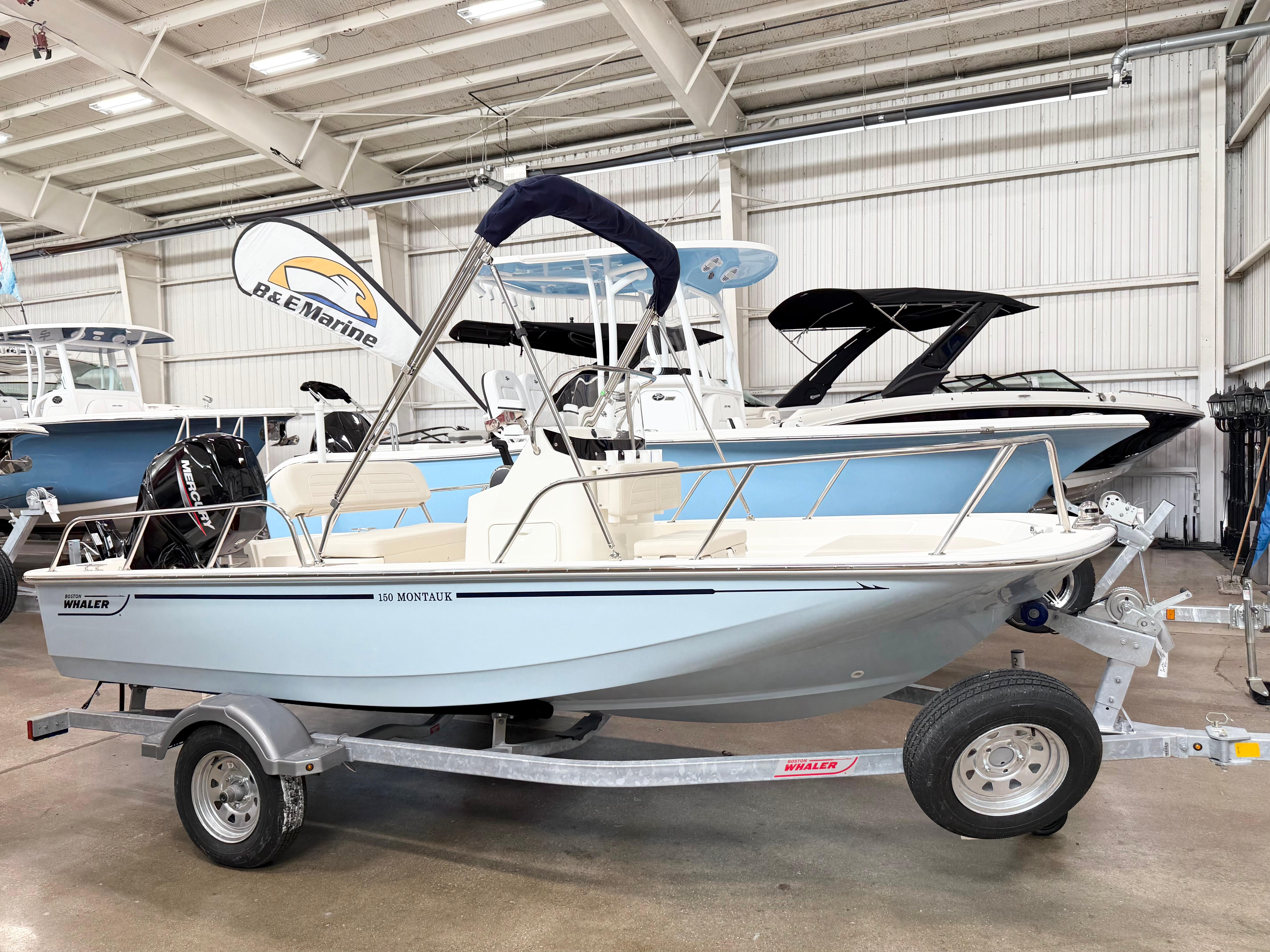 Boston Whaler 150 Montauk 2025 Boston Whaler 150 Montauk boat on trailer in showroom.