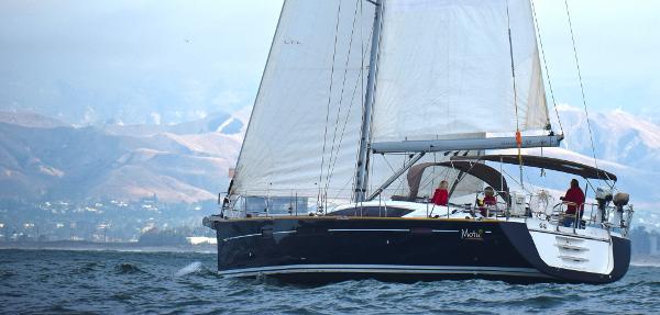 Jeanneau 57 2013 Jeanneau 57 sailboat cruising on open water with mountains in the background.