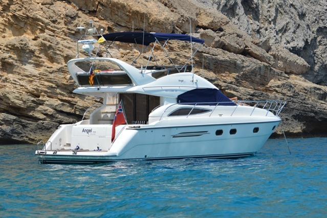 Princess 45 Flybridge 2003 Princess 45 Flybridge yacht anchored near rocky coastline.