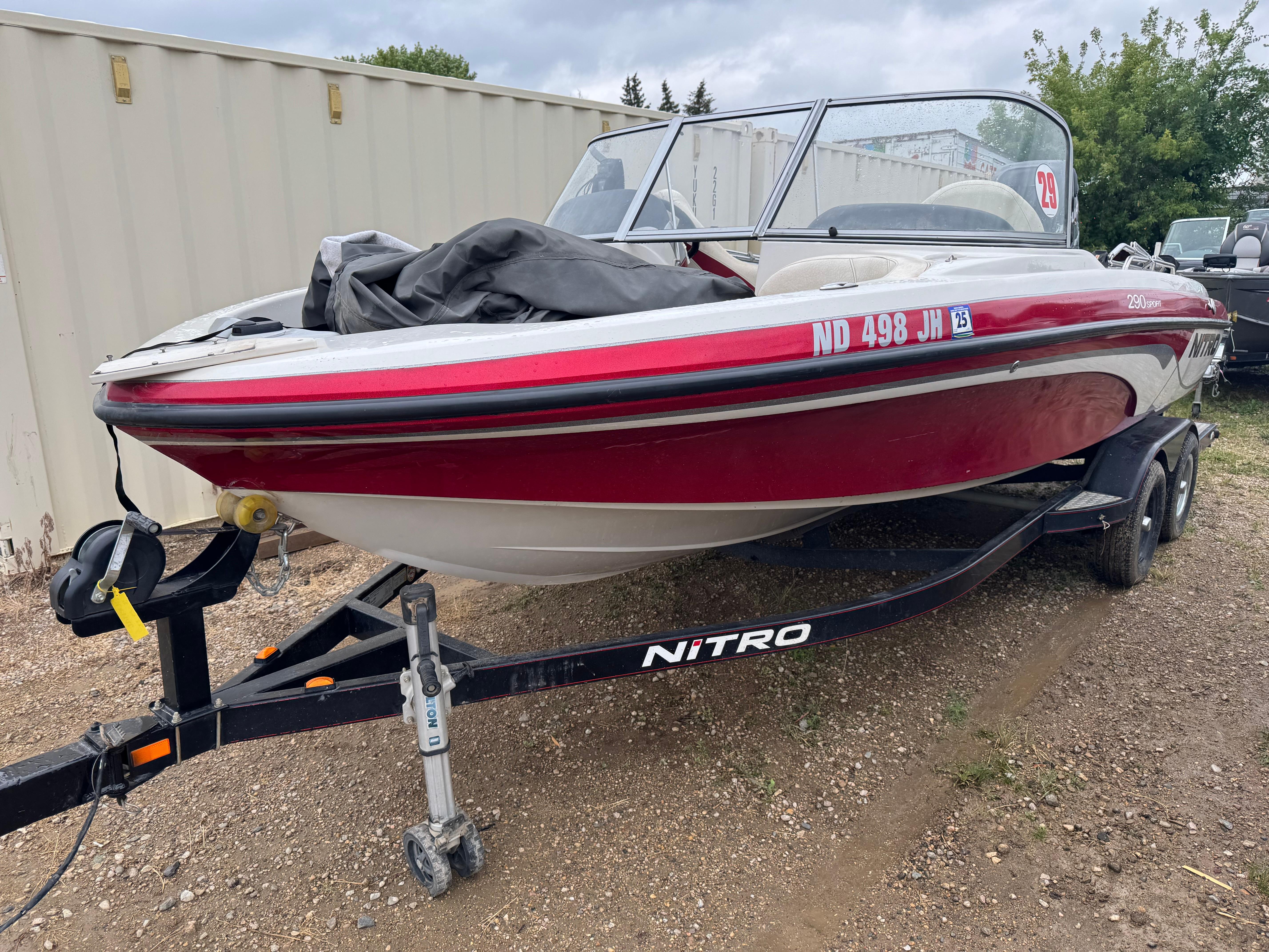 Nitro 290 Sport 2011 Nitro 290 Sport boat on trailer, red and white, parked outdoors.