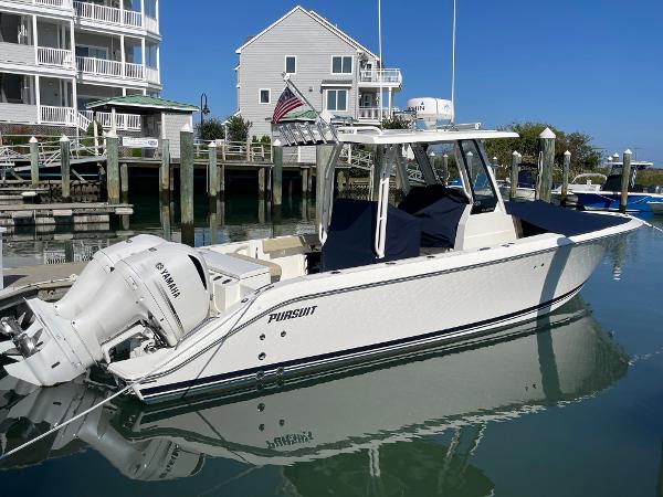 Pursuit S 288 2020 Pursuit S 288 boat docked, featuring Yamaha outboard motor, near waterfront homes.
